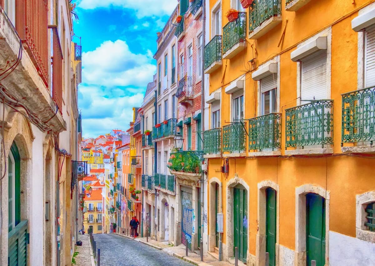 Vibrant hillside street in Lisbon, Portugal, where historic charm meets modern convenience with DDD Invoices enabling seamless digital invoicing solutions.